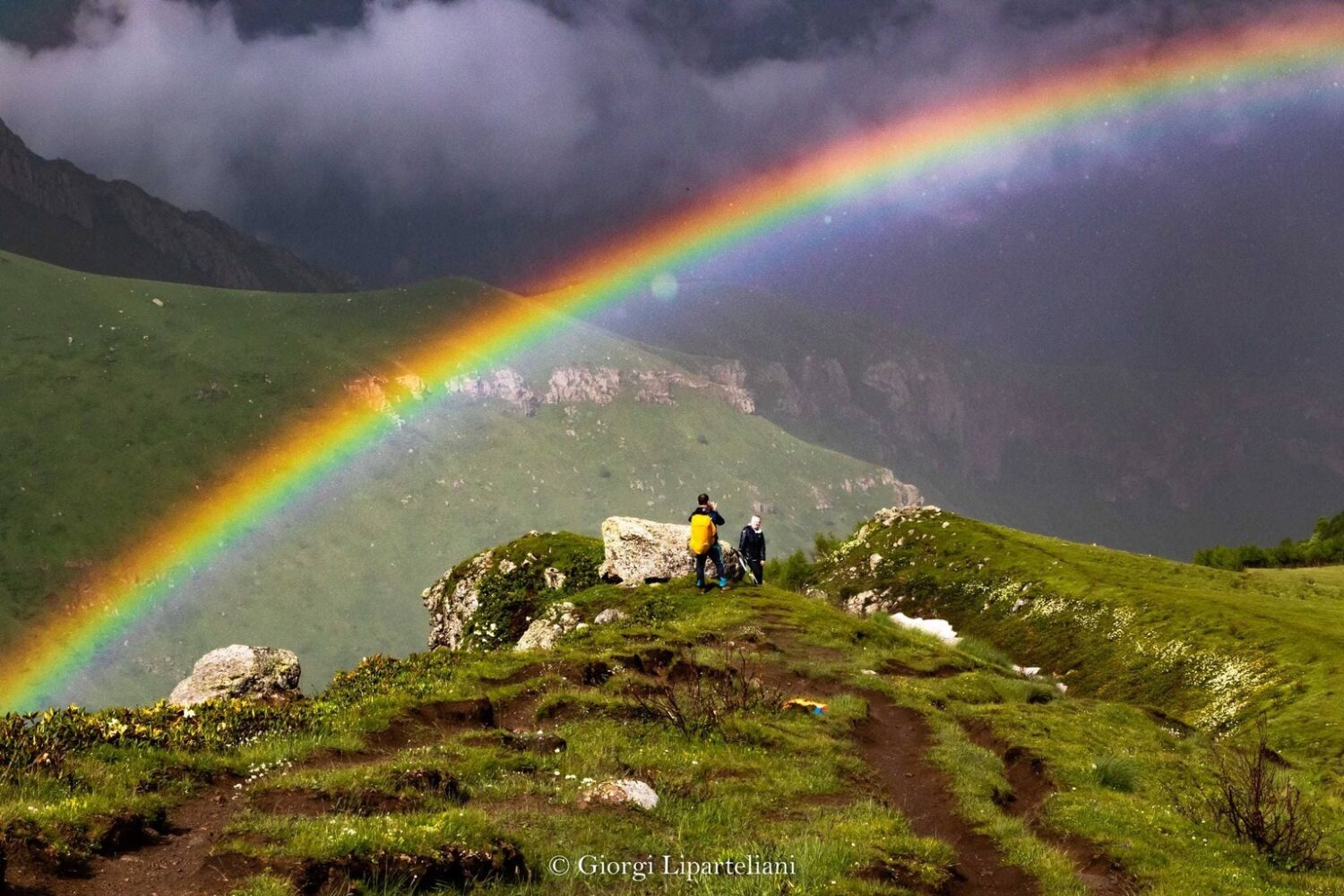 Touristen mit Regenbogen in Stapantsminda auf Rundreise Georgien für Selbstfahrer